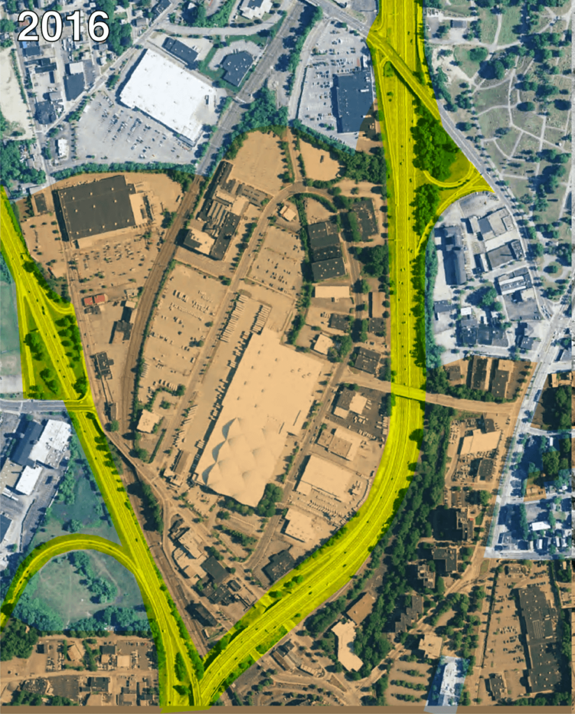 The second is labeled 2016 and shows the same area with a large commercial structure (the Providence Postal distribution center) and various other industrial structures surrounded by expansive parking lots, along with a wide highway snaking from north to south and curving west toward the bottom of the photo.